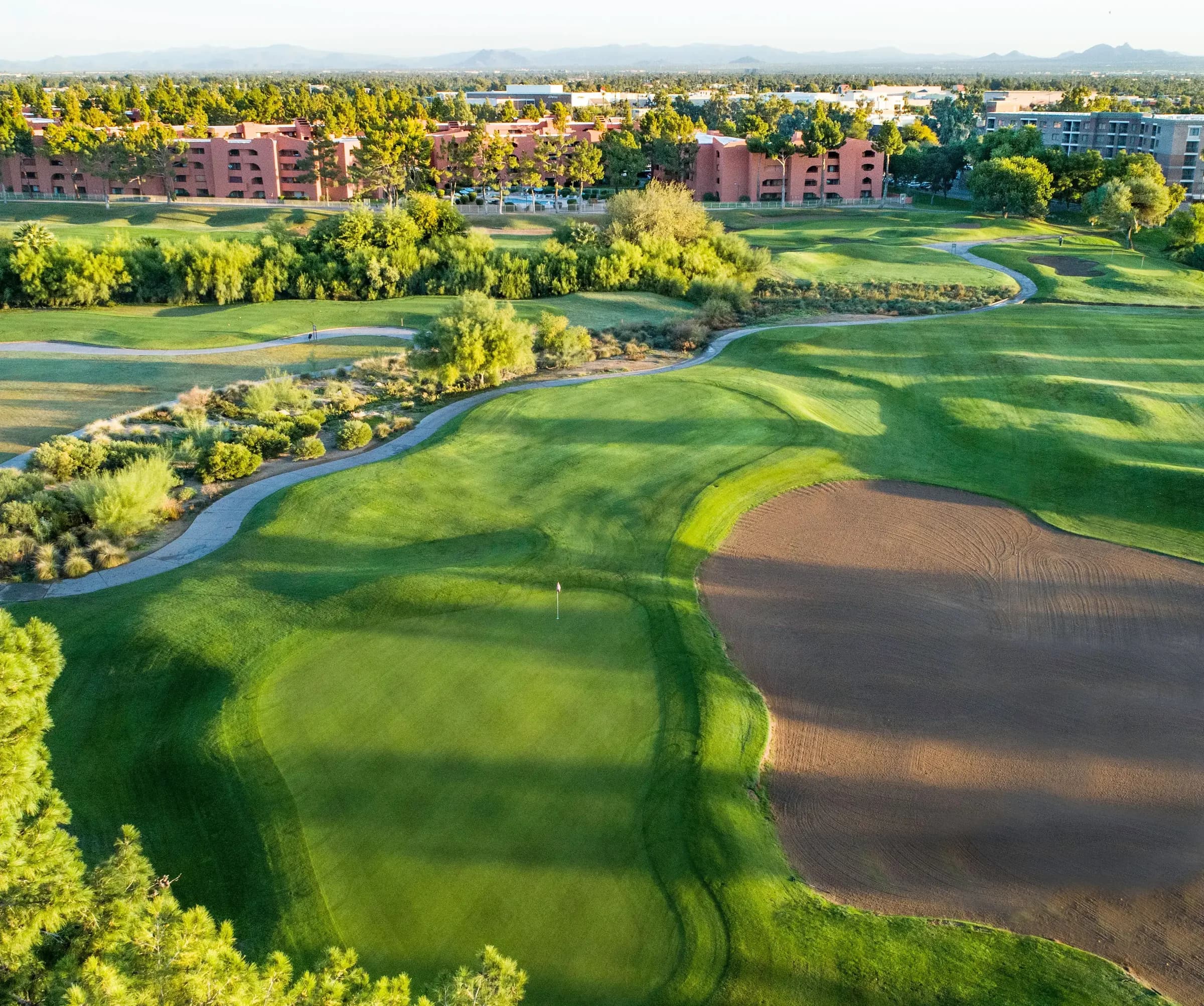 Aerial view of the third hole, its fairway framed by a wide sand area and desert plantings